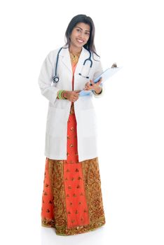 Portrait of full body Indian female doctor in uniform with medical test report, standing isolated on white background.