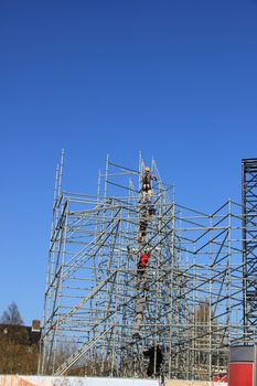 Scaffolding workers building a new construction, pure teamwork