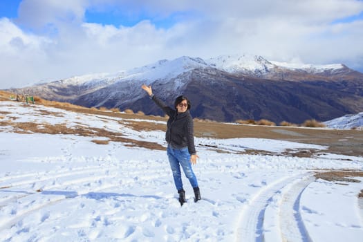 asian woman with happiness emotion standing in ice snow field in queentown south island new zealand use for traveling and tourism scene