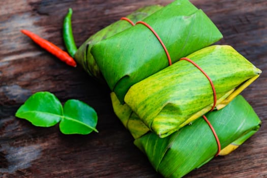 Sour pork Thai northeastern style food which mixed pork rice garlic sugar and salt in banana leaf package.