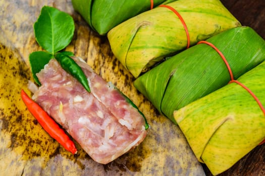 Sour pork Thai northeastern style food which mixed pork rice garlic sugar and salt in banana leaf package.