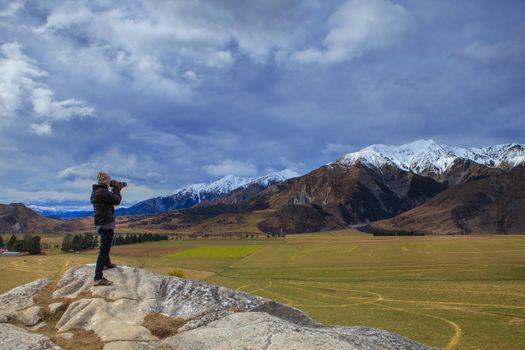 photographer taking a photo on rock cliff of castle hill view point in road to arthur pass national park south island new zealand important destination to visiting