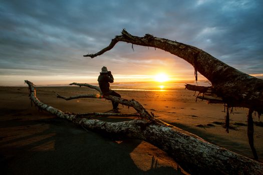 photographer and sun set on black beach hokitika south island new zealand 