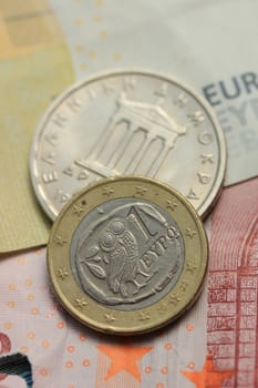 Greek Drachma and euro coin on bank note