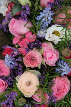 pink roses and ranonkels, blue common hyacints in a spring flower wedding centerpiece