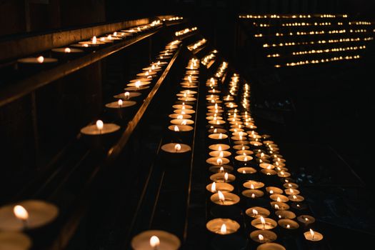 Many burning candles in a church.