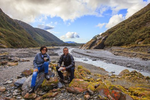 couples of asian traveler taking a photograph in franz josef glacier important traveling destination in south island new zealand 