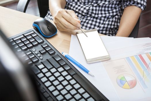 hand of working woman with smart phone writing pen on touching screen with copy space on office working table