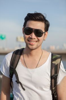 close up face of younger asian man wearing sun glasses standing outdoor