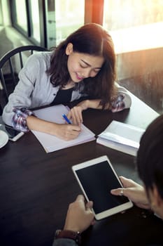 younger asian woman working with happiness emotion on office table with partner team