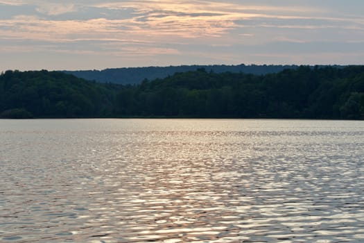 Beautiful landscape with the lake and the forest on the sunset