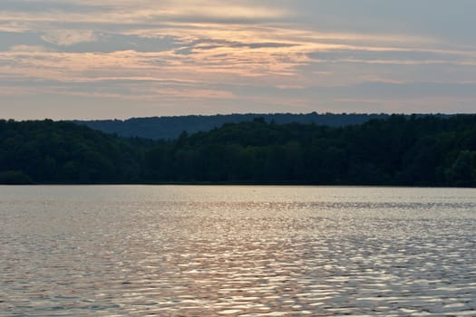 Beautiful landscape with the lake and the forest on the sunset