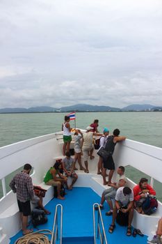 PACIFIC OCEAN, THAILAND - NOVEMBER 29, 2013: lot Passenger ferry floating in open ocean, tourists on deck looking forward, toned, soft light