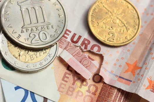 Euro crisis, a vintage Greek Drachma coin and a torn euro note