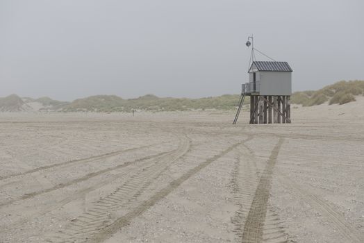 The sea cottage of Terschelling is from the end of 2015 posted near pole 24 on the North Sea Beach at the dunes on a larger and more secure distance from the North Sea on a new location. Picture was taken on a foggy and drizzly autumn day
