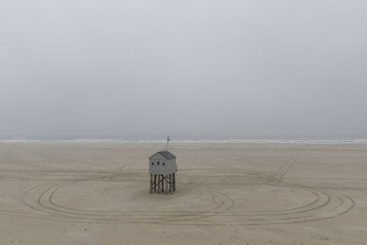 The sea cottage of Terschelling is from the end of 2015 posted near pole 24 on the North Sea Beach at the dunes on a larger and more secure distance from the North Sea on a new location. Picture was taken on a foggy and drizzly autumn day
