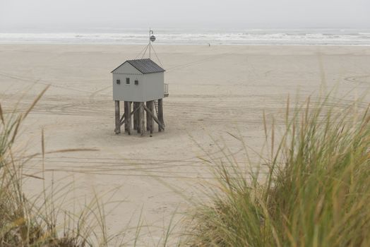 The sea cottage of Terschelling is from the end of 2015 posted near pole 24 on the North Sea Beach at the dunes on a larger and more secure distance from the North Sea on a new location. Picture was taken on a foggy and drizzly autumn day
