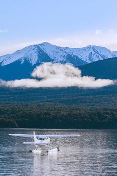 water plane floating over fresh water lake against beautiful mountain scenery in lake te anau new zealand