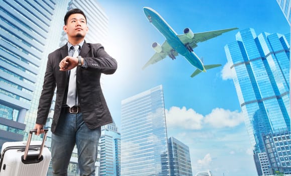 business man and belonging luggage watching to sky and hand watch against high building skyscrapers and passenger plane flying above use for aircraft ,air transportation ,traveling of people theme 