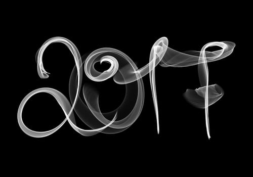 2017 isolated numbers written with white smoke or flame light on black background.