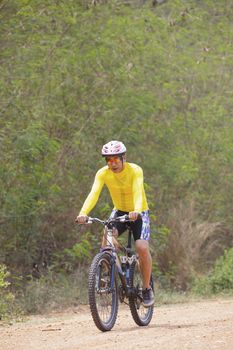 young man riding mountain bike in dusty road use for sport leisure and healthy activities