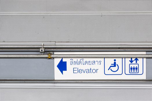 blue sign with human symbo and man on the wheel cahir symbo telling the elevator at the left on the wall at train station in Bangkok, Thailand, 2016 