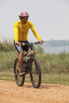 young man wearing rider suit riding mountain bike MBT on dusty road use for sport activities and male outdoor sport