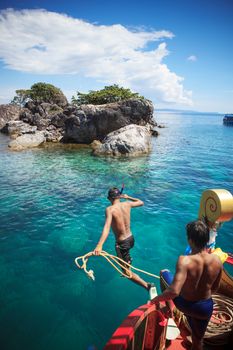 TRAT THAILAND - OCT29 : boat working man with rope jumping to the sea when the boat run into shallow of sea water for snorkeling around the island on October29, 2014 in Trat eastern of  Thailand 