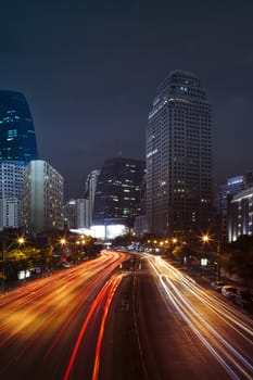 vehicle lighting on urban road and building against night scene sky of bangkok thailand
