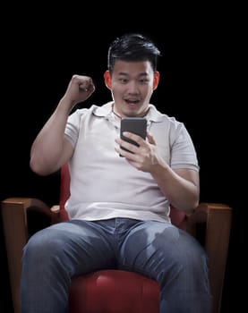 man sitting on arm chairs and watching to smart phone with exciting face 