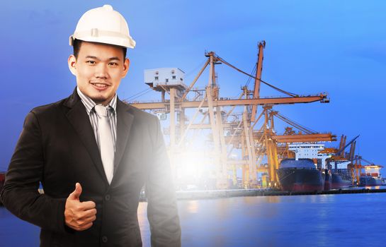 young manager man standing and sign good quality control of port shipping import export and logistic industry service against ship in comercial ship piers  