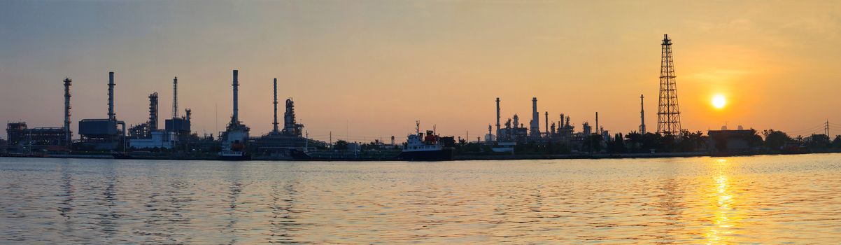 beautiful sun rising scene with oil ,gas refinery industry estate and marine tanker logistic port