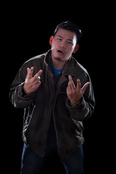 portrait face of young asian man acting like a rocker man standing against dark background 
