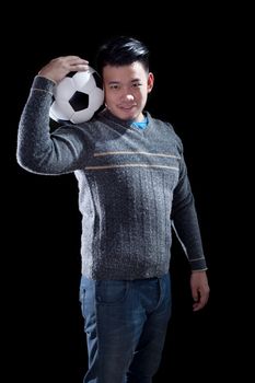 young man holding soccer football with smiling face standing against black background use for people and sport hobby