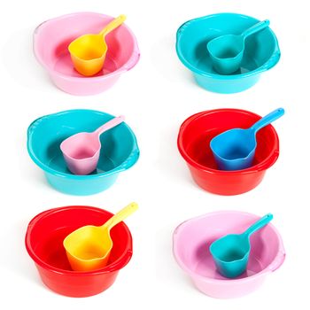 several plastic basins with ladles on the isolated white background