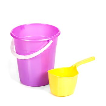 yellow plastic ladle near a bucket on the white isolated background