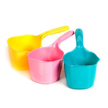 multi-colored plastic ladles on the white isolated background