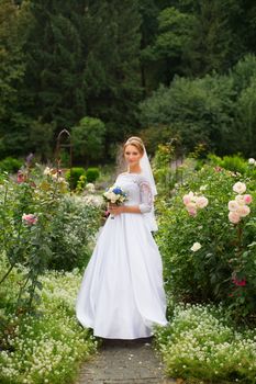 Portrait of a bride in a stylish white dress close-up outdoors