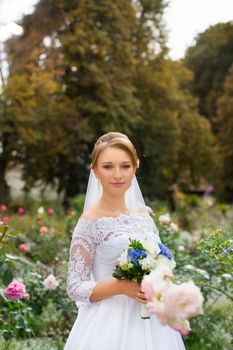 Portrait of a bride in a stylish white dress close-up outdoors