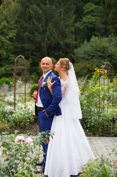 Bride gently pressed her to the groom on the background of nature