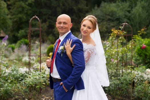 Bride gently pressed her to the groom on the background of nature