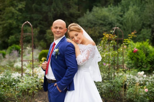 Bride gently pressed her to the groom on the background of nature