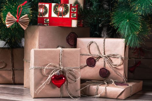 Stacks of wrapped Christmas gifts under the tree in a living room