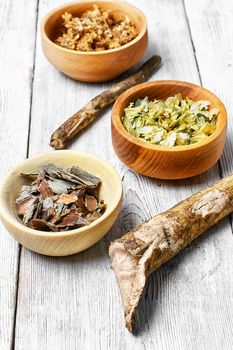 Medicinal herb in the wooden bowl and inula root