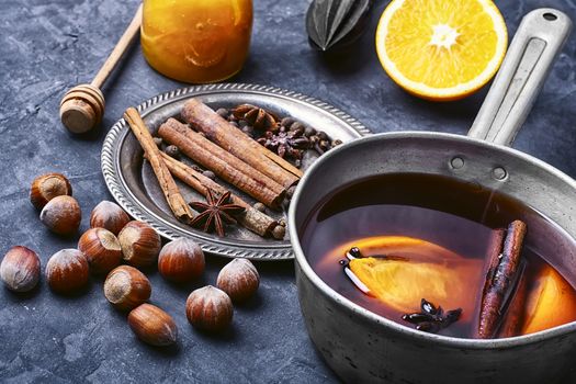 Hot wine with orange and spices set on a dark slate background