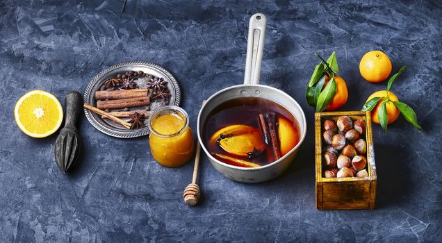 Hot wine with orange and spices set on a dark slate background