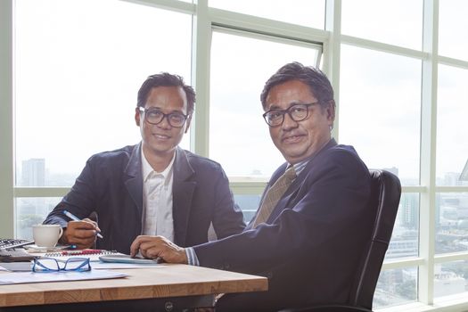 couples of business man working on office working table with smiling face looking to camera