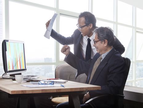 couples of business man happiness emotion when looking to business graph report on computer monitor 