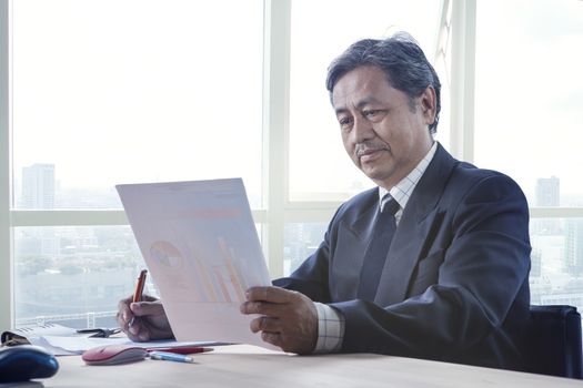 senior working man reading business paper report on working table use for people in office life 