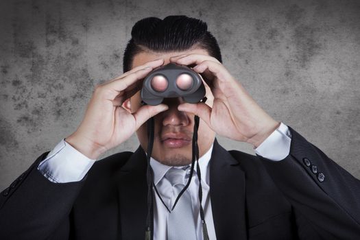 business man looking through binocular lens use for business strategy , and way to success 